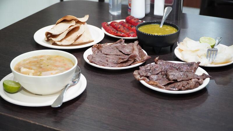 Mesa servida con carne asada y acompañamientos